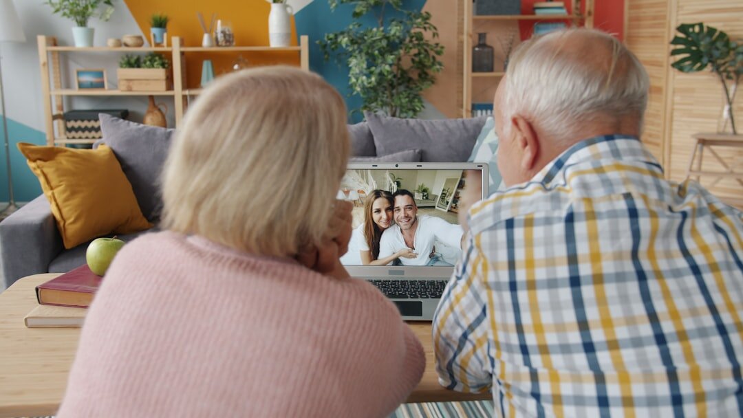 Older man having a video call with family on a laptop